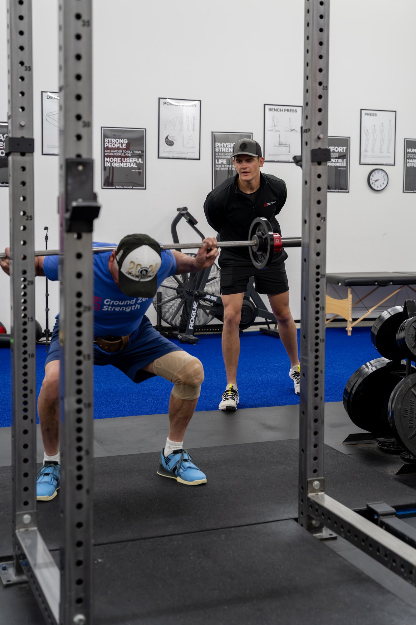 A coach cueing a lifter through a squat